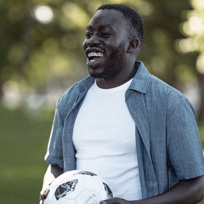 Smiling young man holding a football.